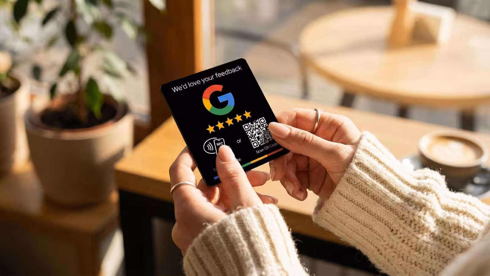 girls hand holding google review plate in a cafe